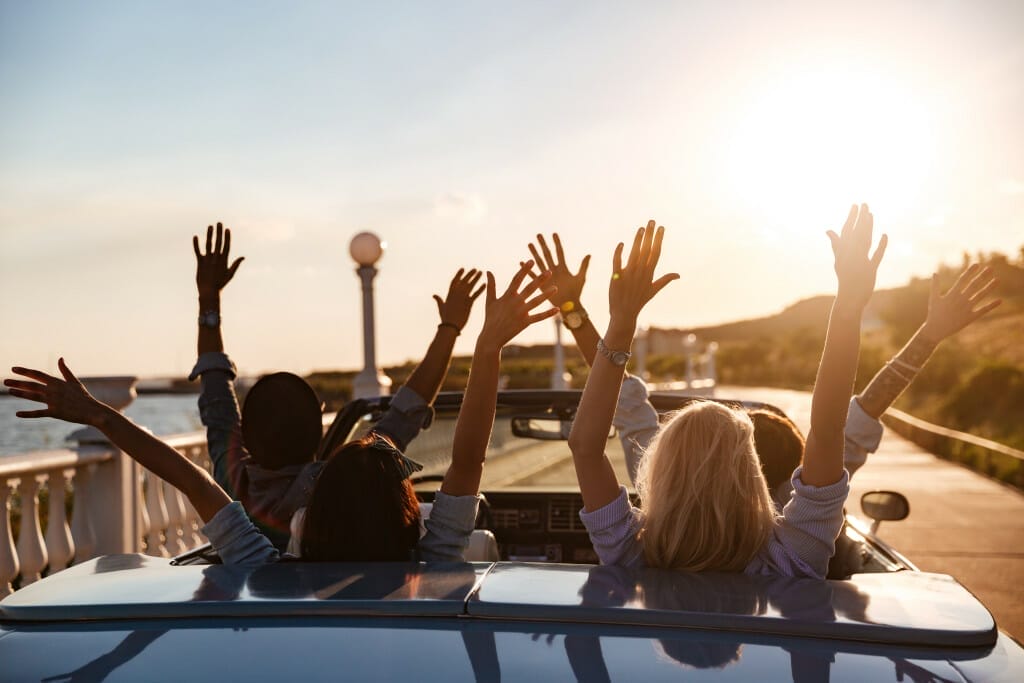 Friends enjoying sunset drive in a convertible sbi 303736663